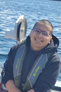 Steve Kashevarof, smiling, on a boat wearing a life-jackey